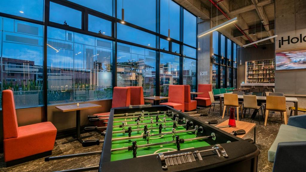 Área con futbolín, sillas coloridas y comedor con decoración contemporánea