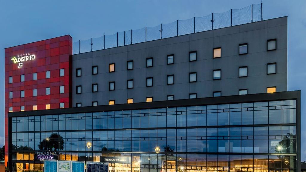 Edificio con fachada gris y roja, vitrinas comerciales y señalización visible