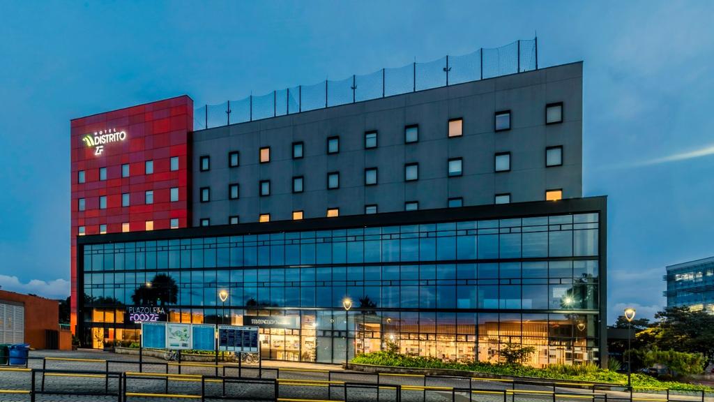 Edificio moderno con fachada de vidrio y estructura gris con detalles rojos