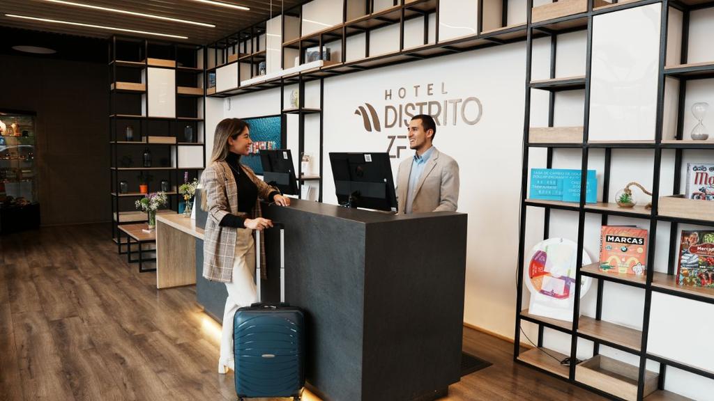 Mujer con maleta en recepción con decoración moderna y estanterías