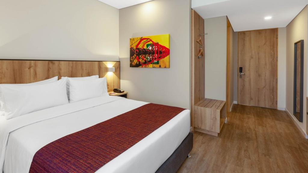 2- Habitación moderna con cama bien presentada, decoración cálida y mobiliario funcional