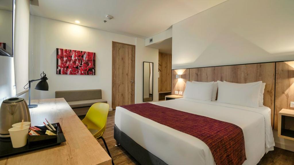 3- Habitación moderna con cama bien presentada, decoración cálida y mobiliario funcional