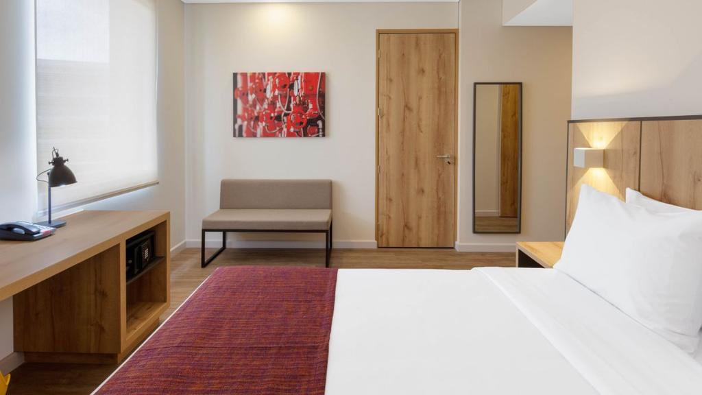 6- Habitación moderna con cama bien presentada, decoración cálida y mobiliario funcional