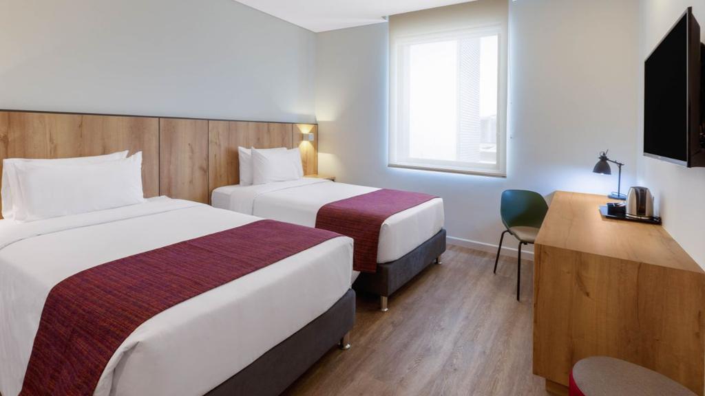 4- Habitación moderna con cama bien presentada, decoración cálida y mobiliario funcional