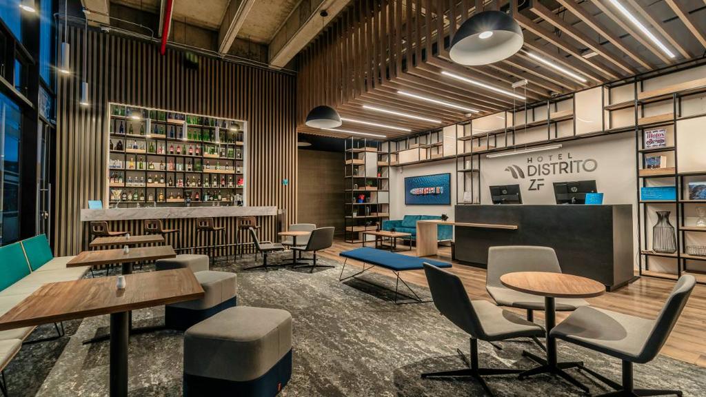 Lobby con luz natural, muebles contemporáneos y detalles en madera